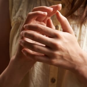 A woman's hands are using tapping for easy relief from headaches with EFT (Emotional Freedom Techniques).